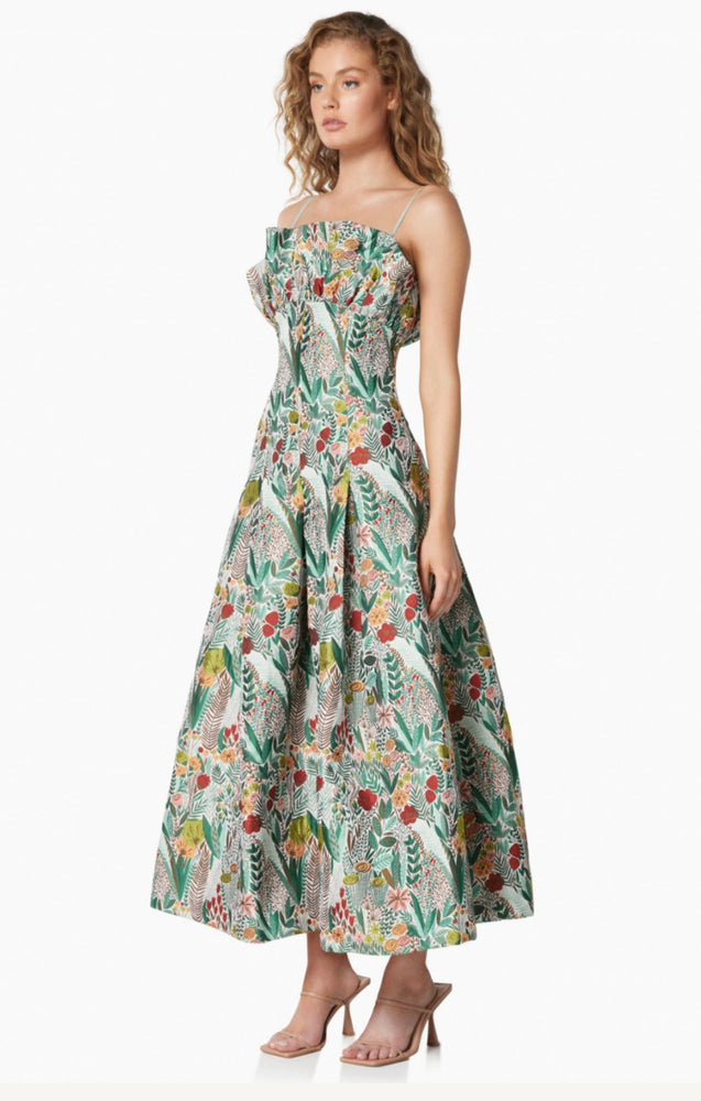 The Juno Dress by Elliatt is a flattering A-Line maxi dress, worn with spaghetti straps, or without to become a strapless dress. In a luxurious green print pattern, with fanned fabric around the bust. 